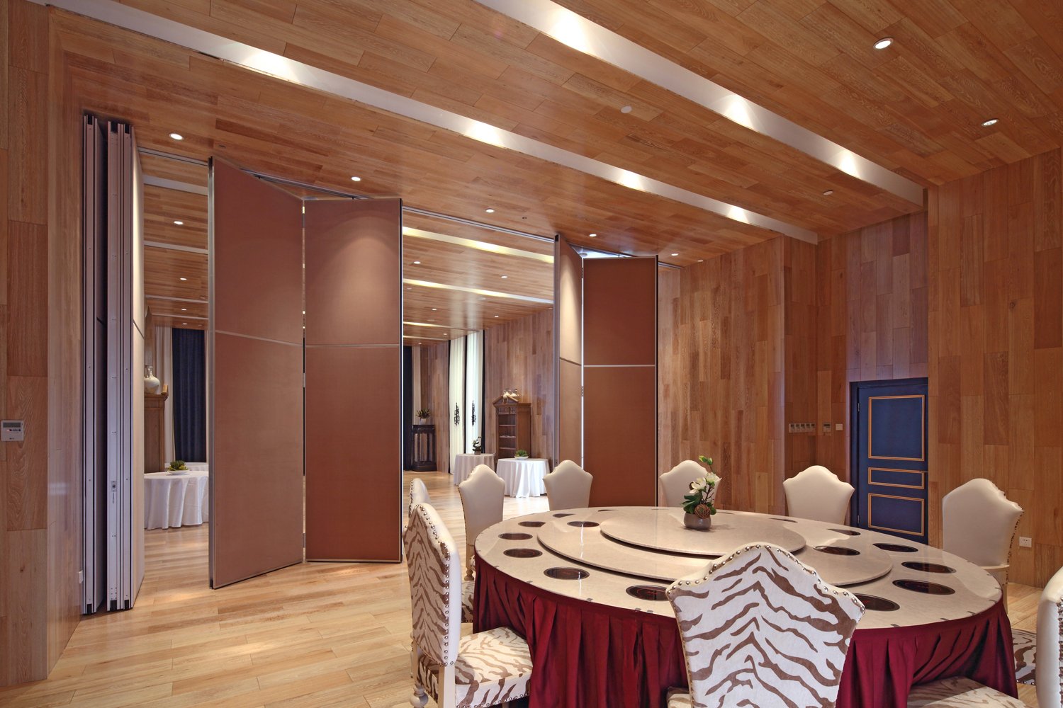 Paired hinged operable partitions folded open beside a banquet table